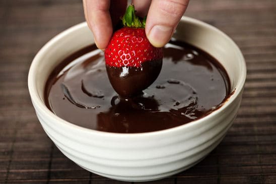 Dipping strawberry in chocolate