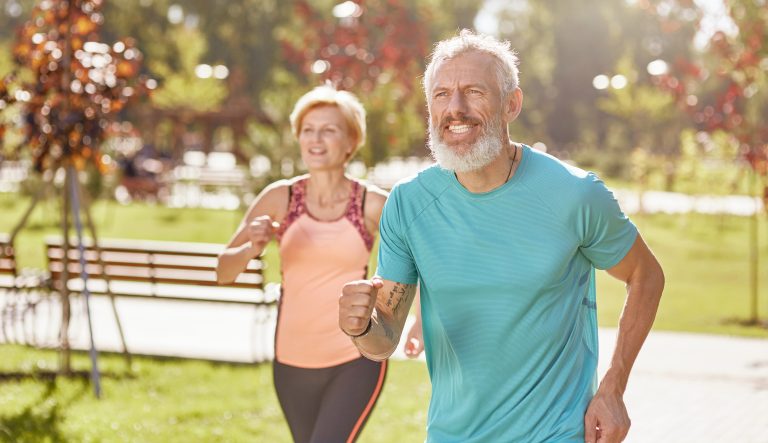 Active, mature man and woman exercising